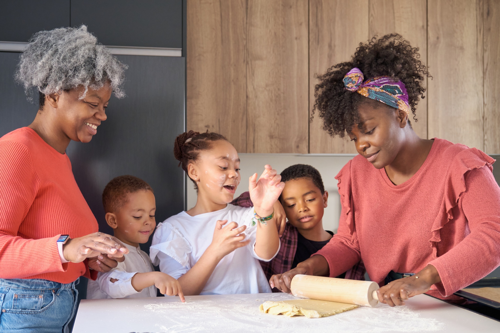 African happy family roll cookie dough out with a rolling pin in the kitchen.