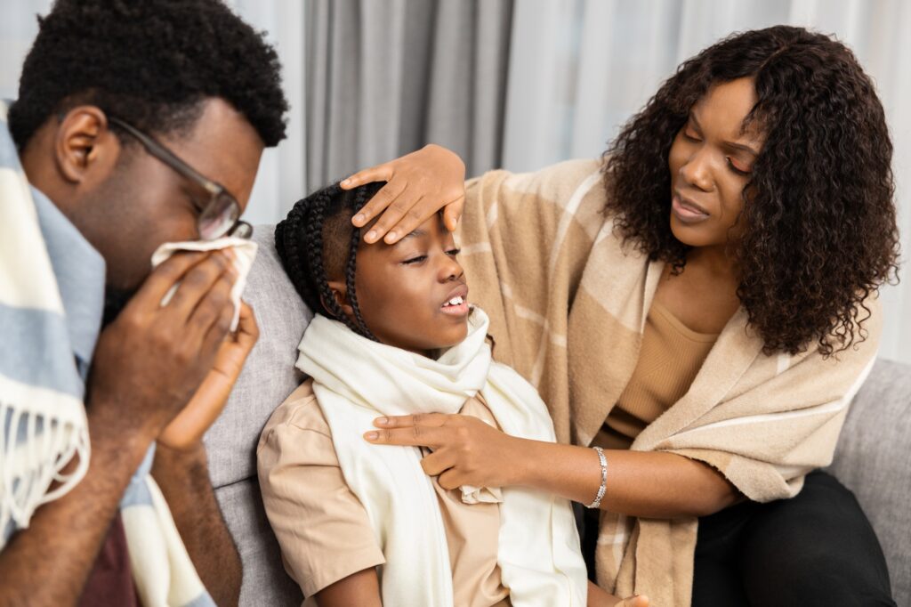 Caring Parents Comforting Sick Child At Home Together