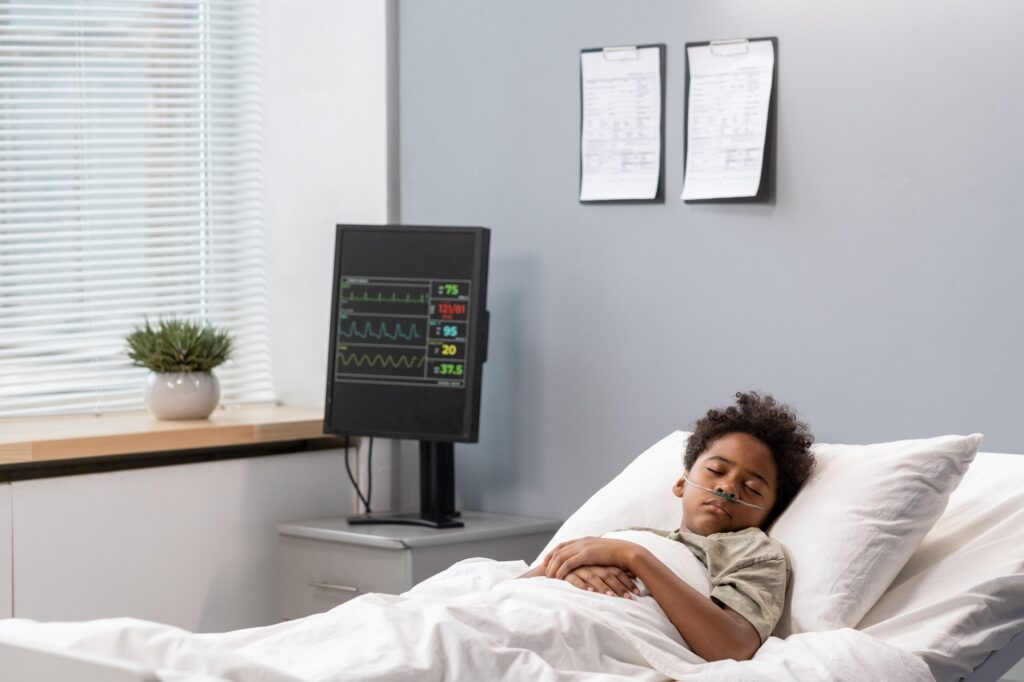 Sick little boy lying at hospital ward